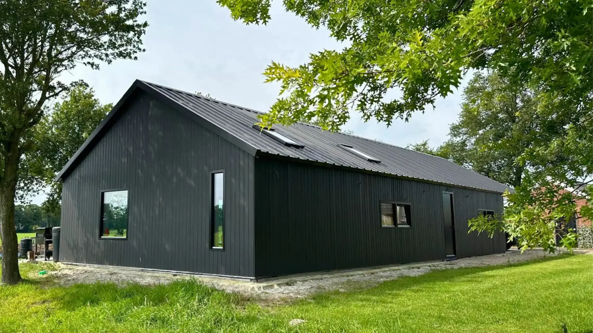 Prefab mantelzorgwoning: ruime, zwarte prefab mantelzorgwoning geplaatst op een groen gazon